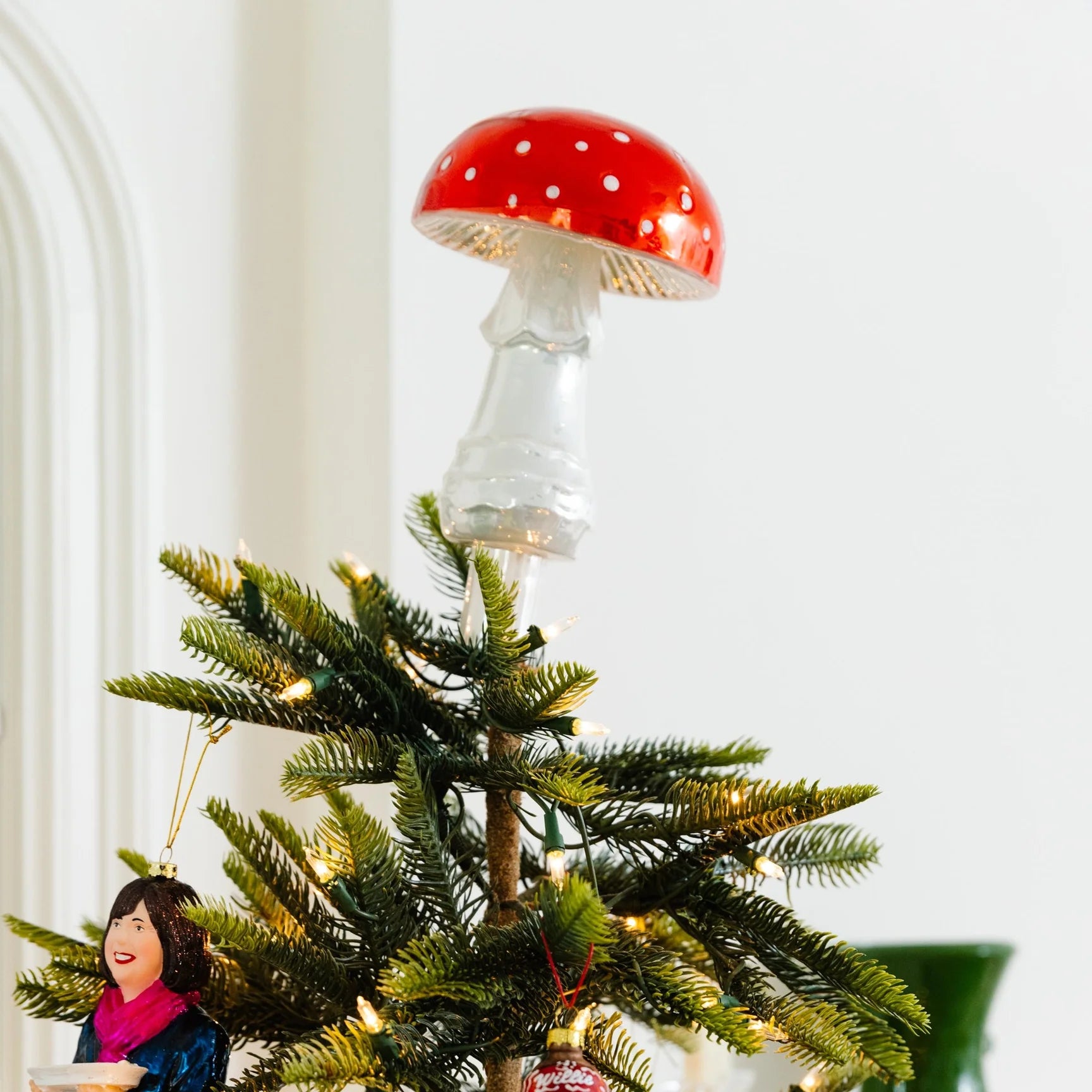 Decorative mushroom ornament on a Christmas tree with a blurred background
